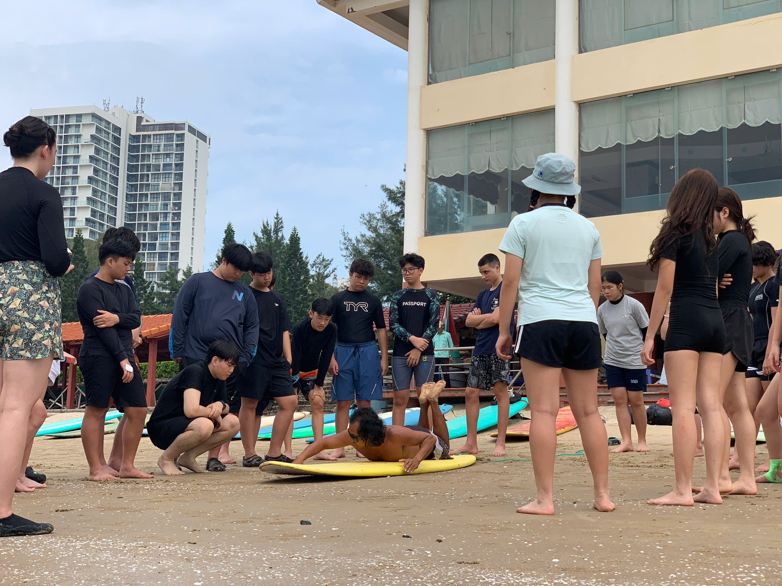 Student practicing a board start on the beach with an instructor nearby