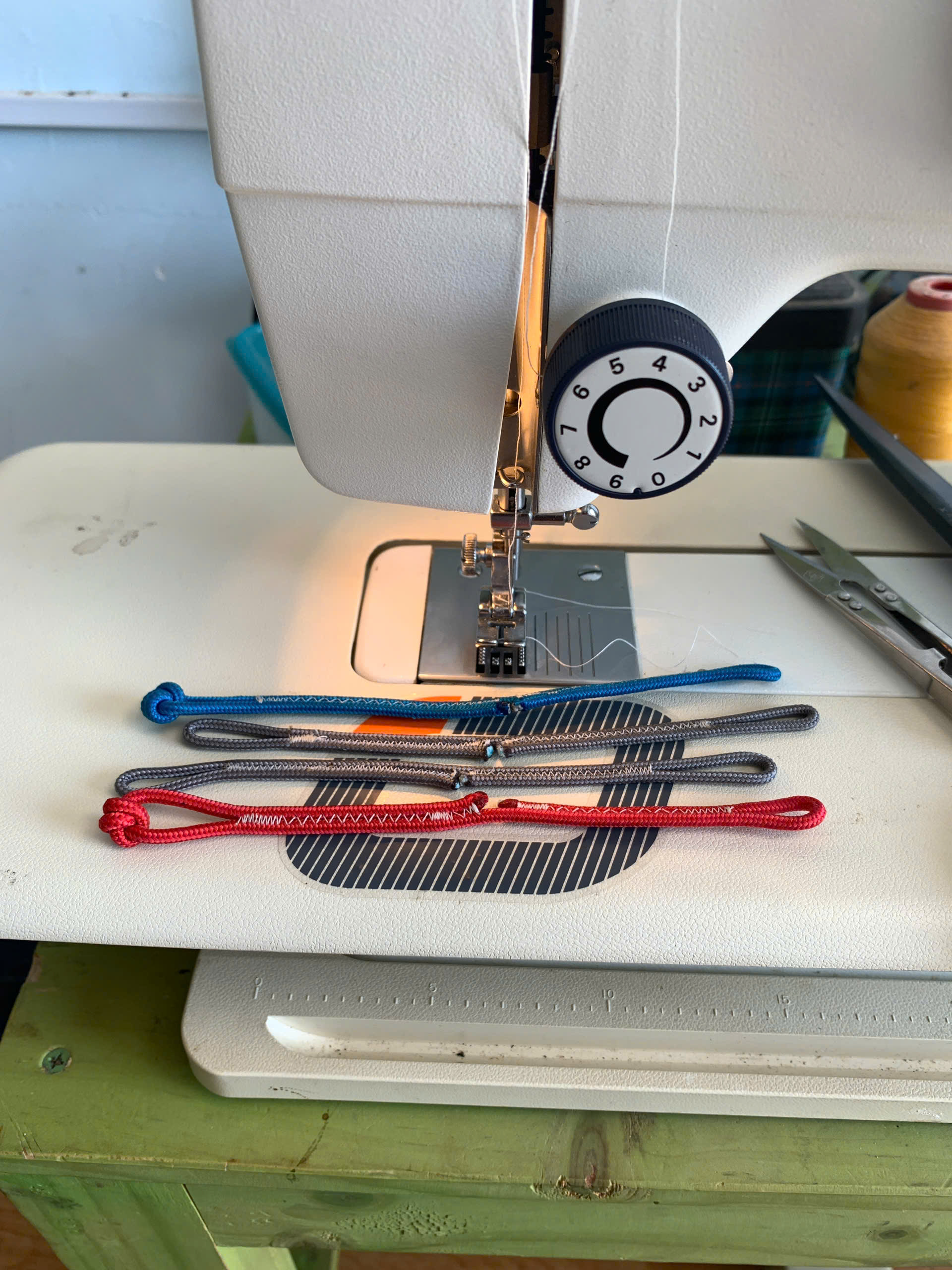 Kite repair lines being sewn on a workshop machine
