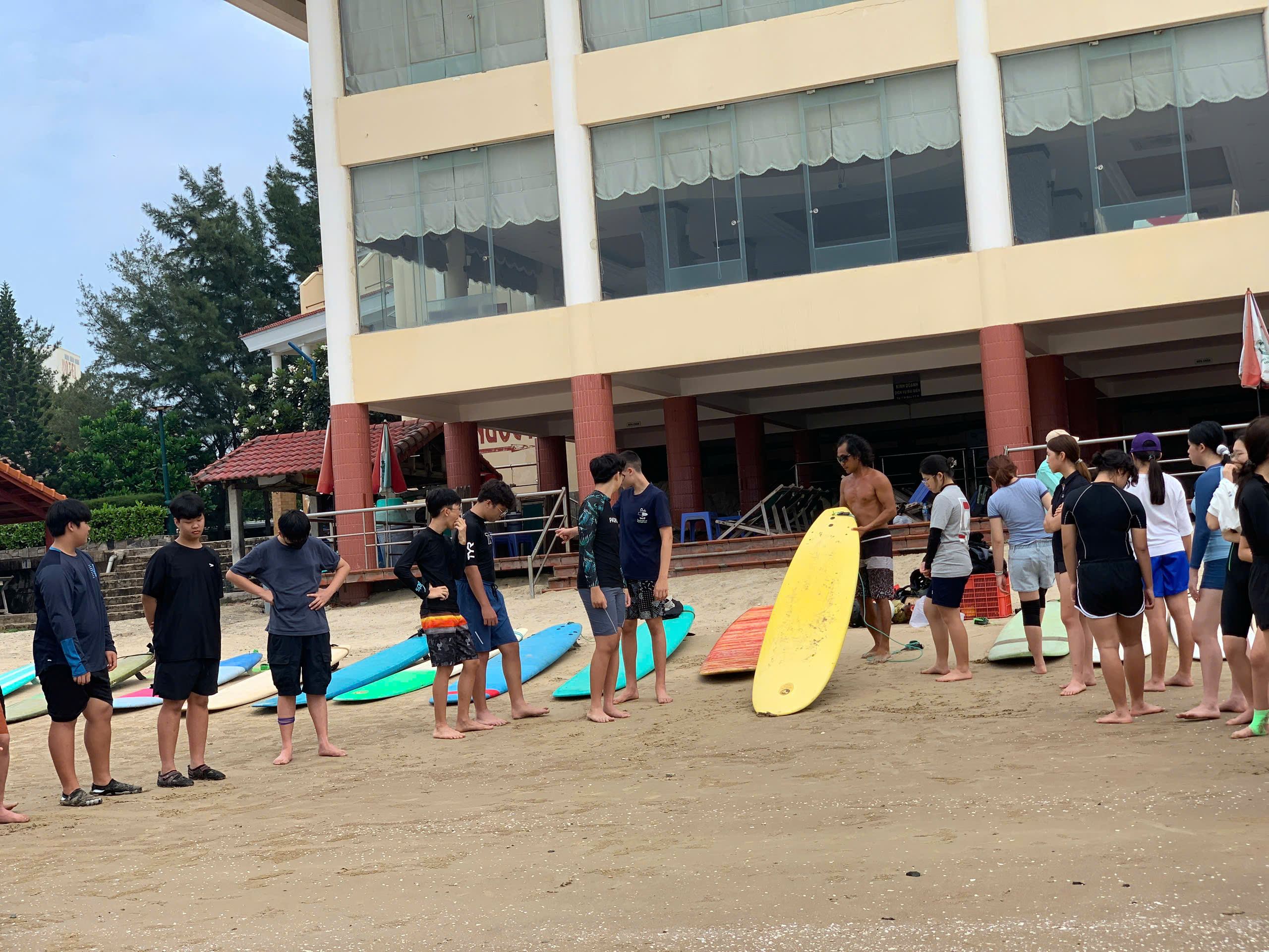 Kiteboarding students gathered on the beach during a lesson