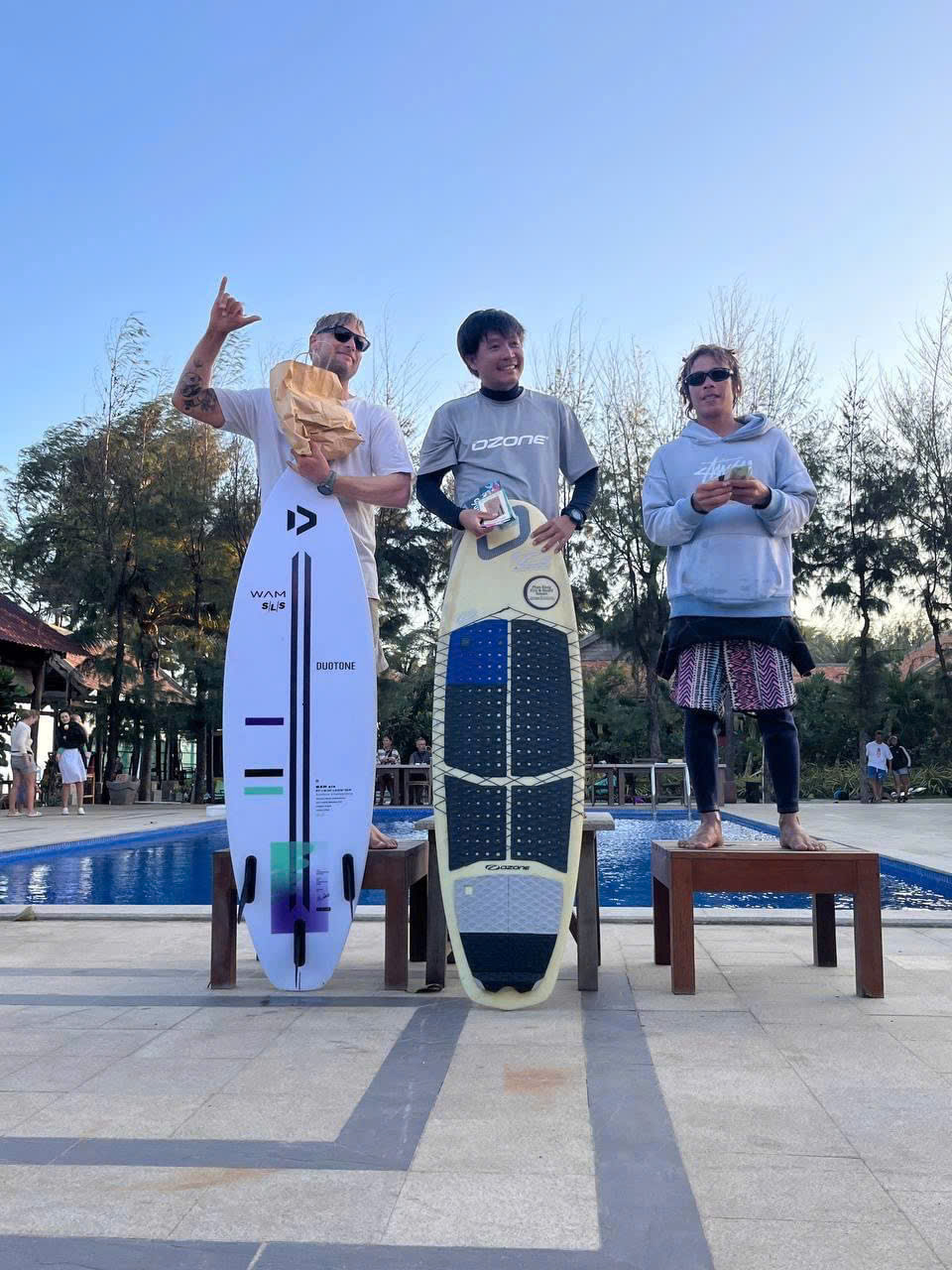 Three riders standing with their kiteboards